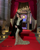 young female adult from bachelorette series wearing gold gown with brown cervinia cashmere fur trimmed cape over her shoulders standing on a red carpet