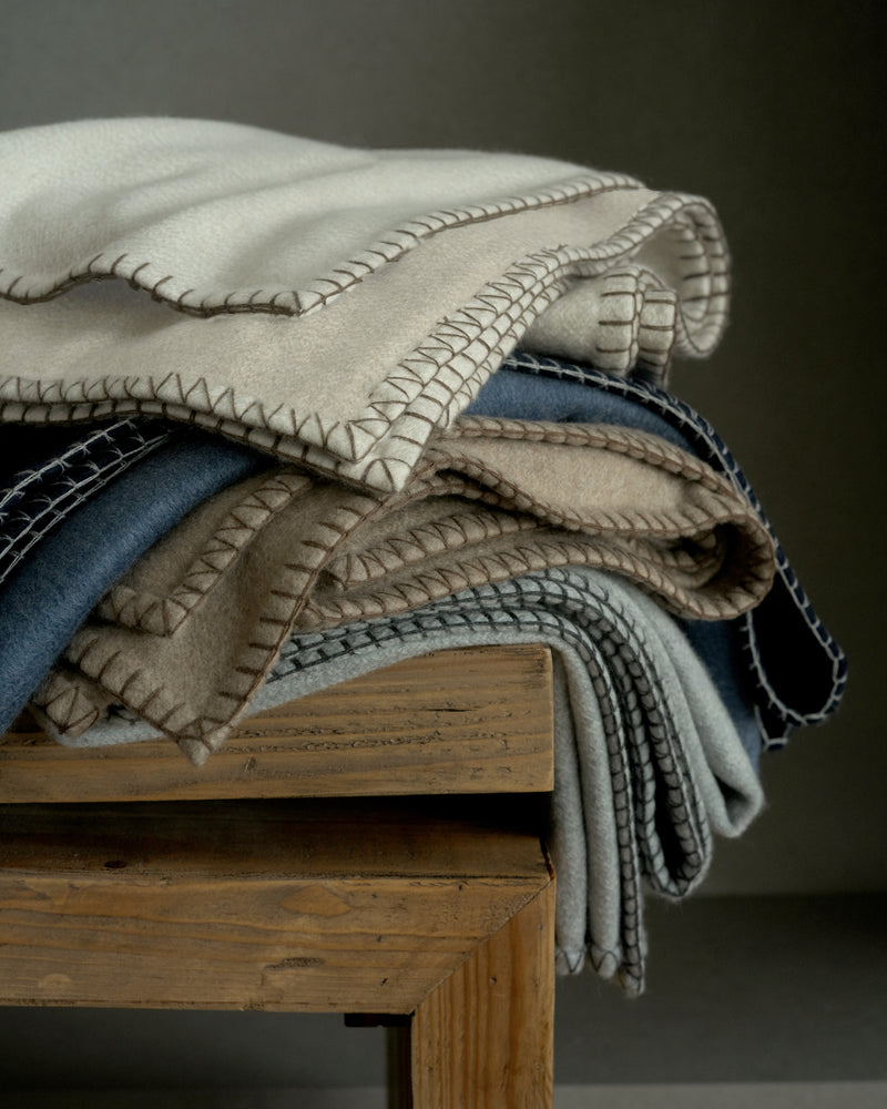 Stack of Gotham Whipstitch Cashmere Throws in Beige