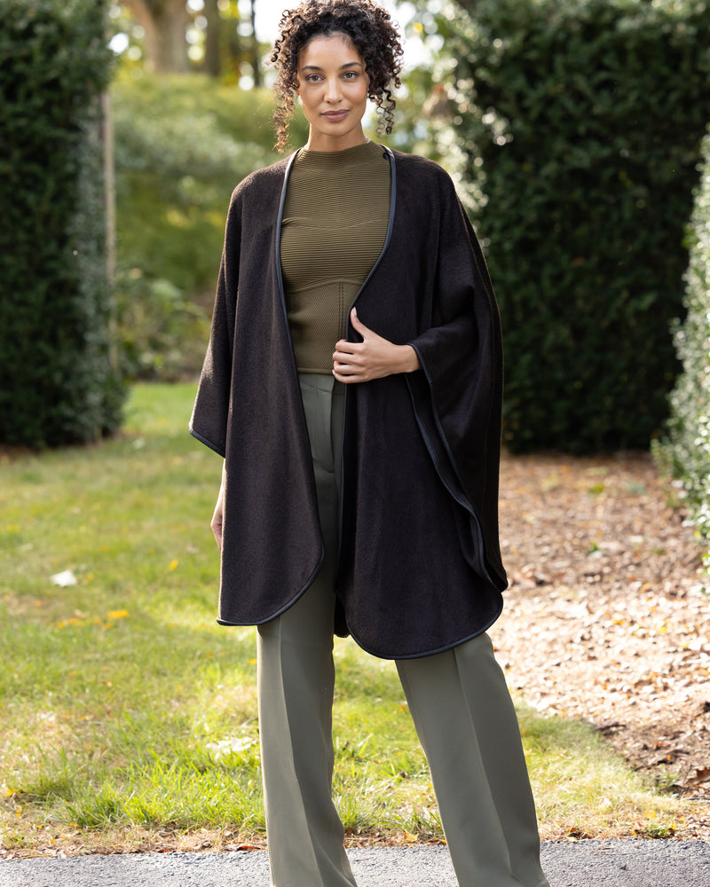 model standing outside wearing Alpaca Wool Cape with Leather trim in Chocolate