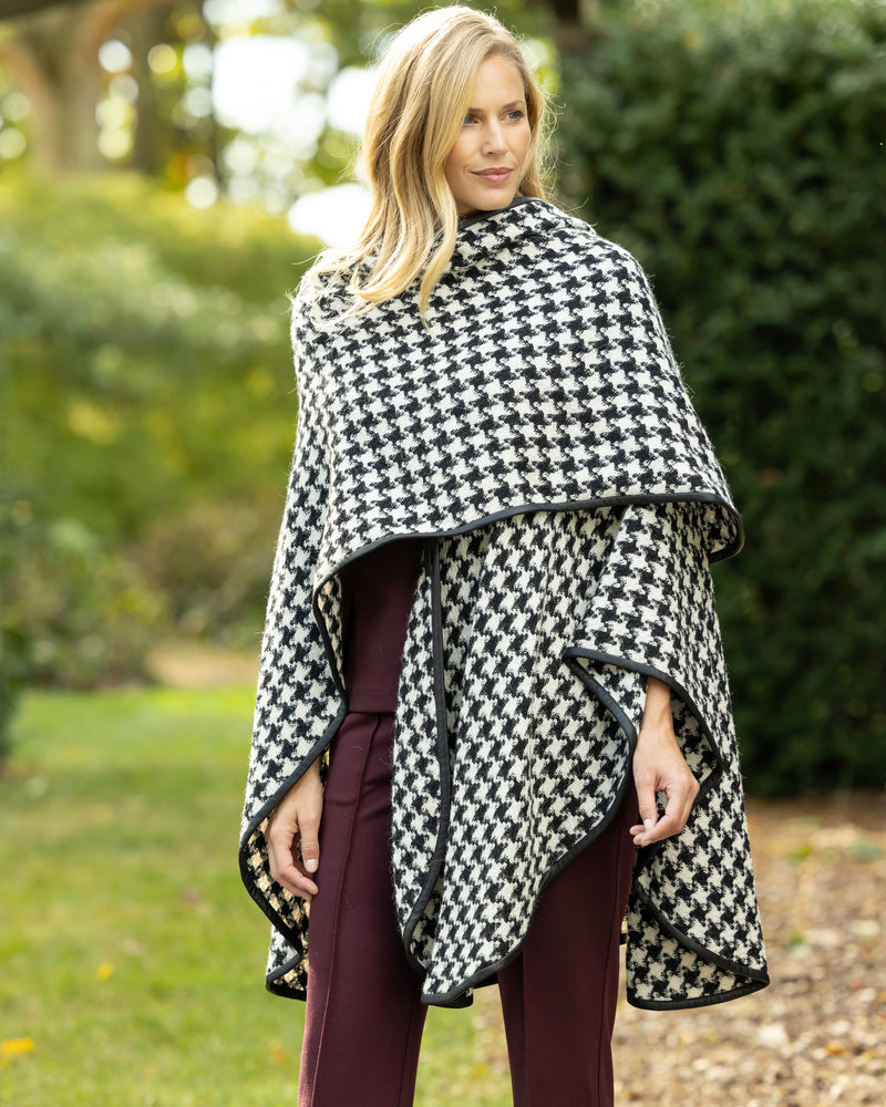 Woman Wearing Alpaca Wool Cape with Leather trim in Black and White Houndstooth Pattern.