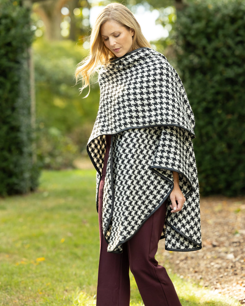 Woman Wearing Alpaca Wool Cape with Leather trim in Black and White Houndstooth Pattern.