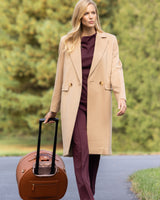 Woman outside walking with roller suitcase and Wearing Pure Cashmere Pick-Stitched Double-Breasted Coat In Camel