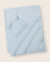 Cable knit baby blanket and pom-pom hat set in soft blue.